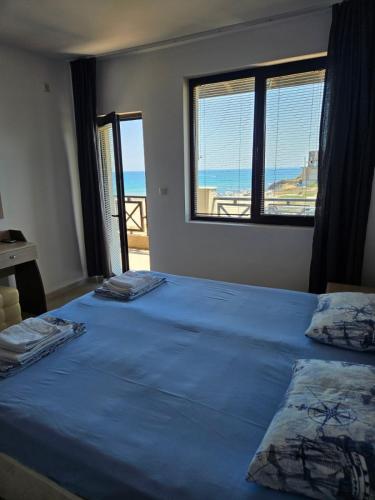 two beds in a bedroom with a view of the ocean at Lozenets Oasis Beach Home Four in Lozenets