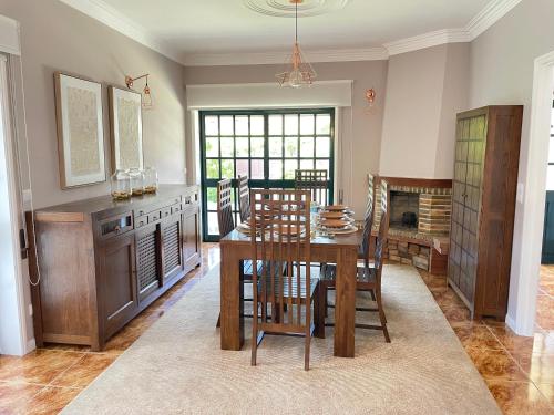 a dining room with a table and chairs and a kitchen at Villa dos Amados in Viana do Castelo