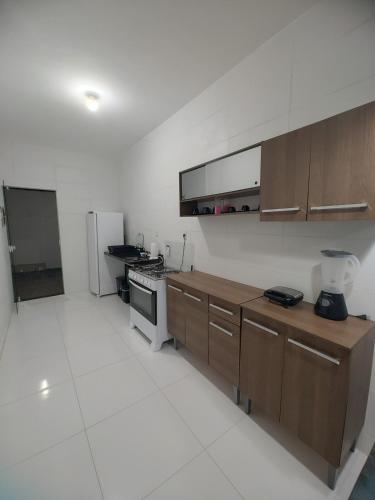 a kitchen with wooden cabinets and a refrigerator at Beach House in Camaçari