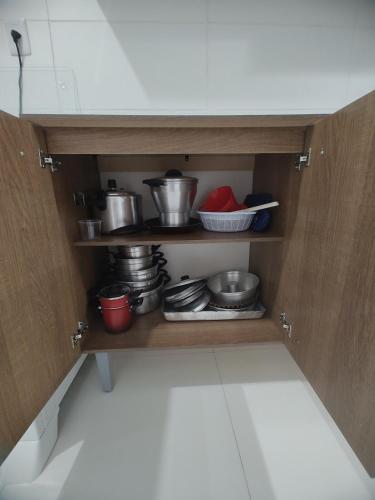 a cupboard with pots and pans in a kitchen at Beach House in Camaçari