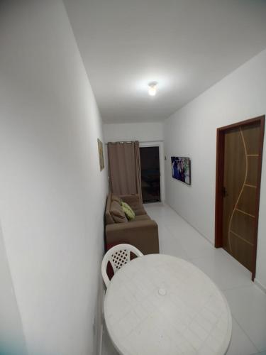 a living room with a white table and a couch at Beach House in Camaçari