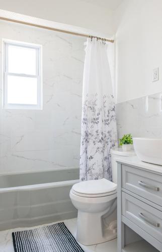 a bathroom with a toilet and a shower curtain at Cozy Home, 23 min from NYC, Home Theater in Lodi