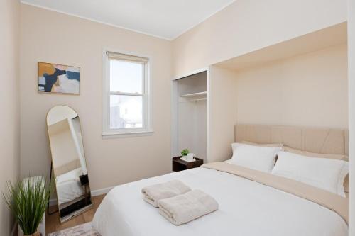 a bedroom with a large white bed and a mirror at Cozy Home, 23 min from NYC, Home Theater in Lodi