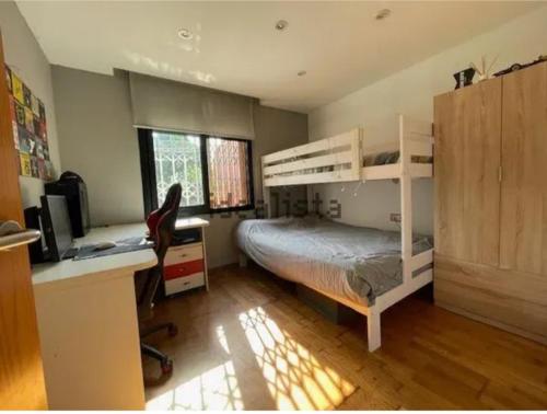 a bedroom with bunk beds and a desk and a computer at Bajo con jardín 1min de la playa in Montgat