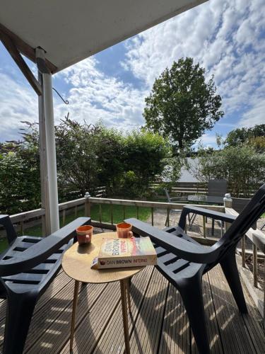 a table and two chairs on a deck with a table at Chalet Corbeth in Putten