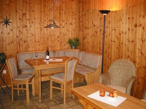 a dining room with a table and chairs at Chalet in Reinskopf with Fireplace & Balcony in Schönecken