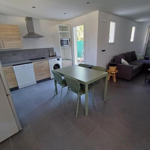 a kitchen and living room with a table and chairs at Ciotat t3 piscine in La Ciotat