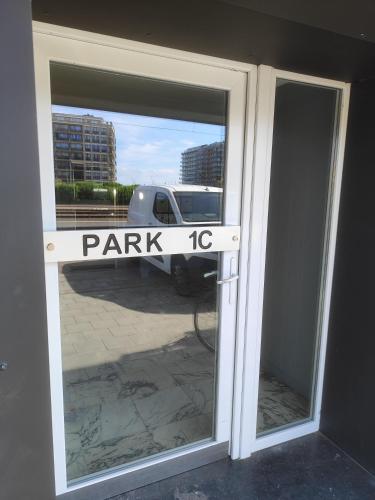 a door with a sign that reads park at Studio met zeezicht in Middelkerke