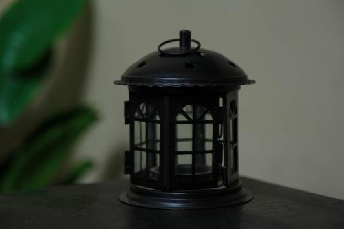 a black lantern sitting on top of a table at Forest Views Haven - Flat 2 in Solwezi