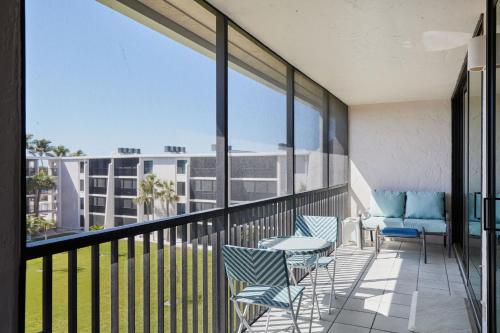 a balcony with chairs and a table and some windows at Sundial F406- Stunning Fully Equipped Residence at Sundial Sanibel in Sanibel