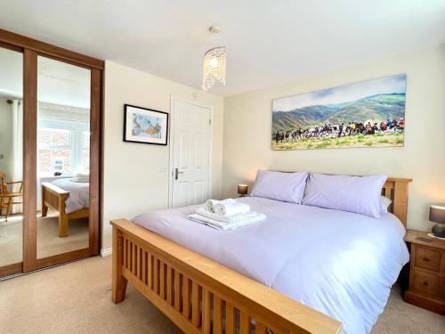 a bedroom with a large bed with a large painting on the wall at Harefield in Morpeth