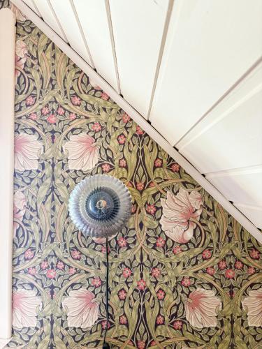 a room with a wall with a floral wallpaper at Romantic Country Cabin With Fjord Views On Åmøy in Stavanger