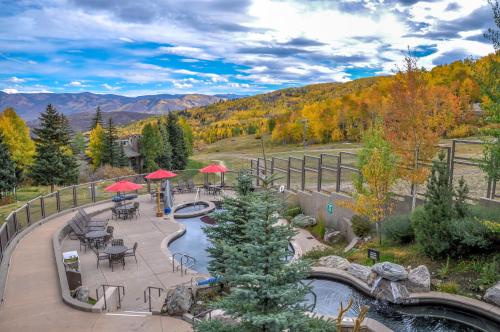 a patio with tables and umbrellas next to a pond at Timberline Condominiums 1 Bedroom plus Loft Deluxe Unit A3C in Snowmass Village