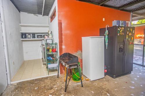 a kitchen with an orange wall and a refrigerator at Relax Quinta carlis 