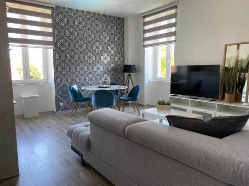 a living room with a couch and a table with chairs at Les Rives des Habsbourg in Ensisheim