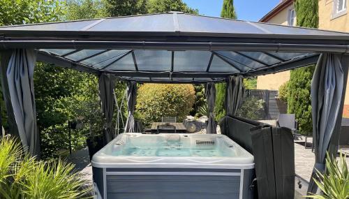 a hot tub under a canopy in a backyard at Les Rives des Habsbourg in Ensisheim