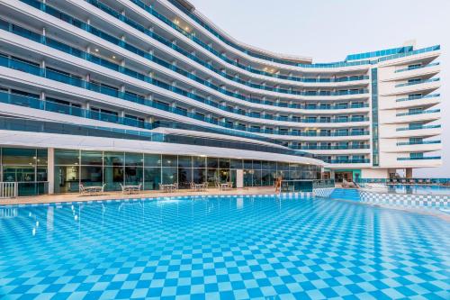 a swimming pool in front of a large building at Las Americas Torre Del Mar in Cartagena de Indias