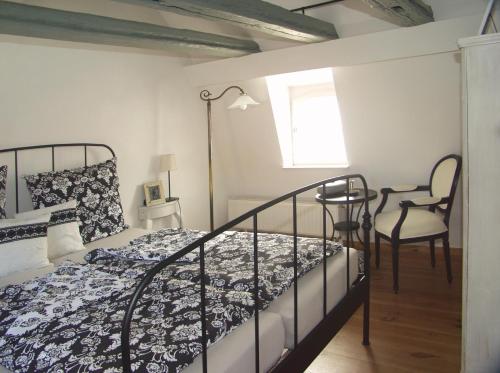 a bedroom with a bed and a chair at Gästehäuser Hölle 12 und Hölle 13 in Bamberg