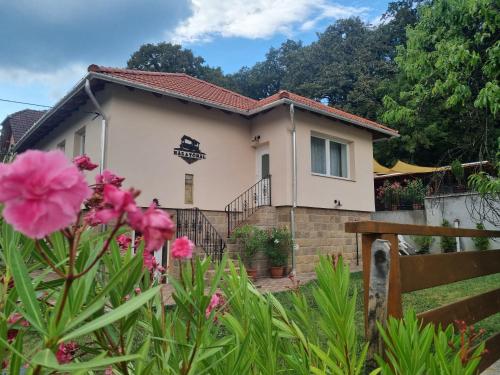 a house with pink flowers in front of it at Ház a tónál Noszvaj in Noszvaj