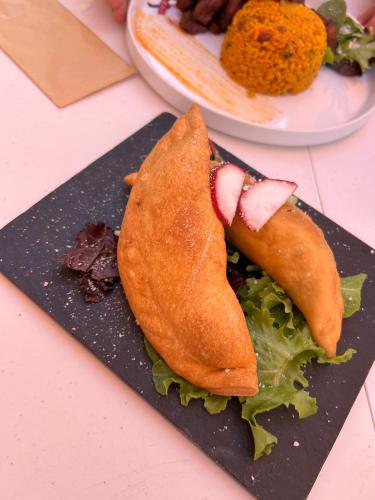 a black plate of food with a sandwich on it at Arecibo's country cottage in Arecibo