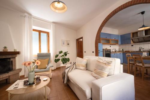 a living room with a white couch and a table at Casa Mario in Riparbella