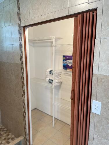a walk in closet with a glass door at Arecibo's country cottage in Arecibo