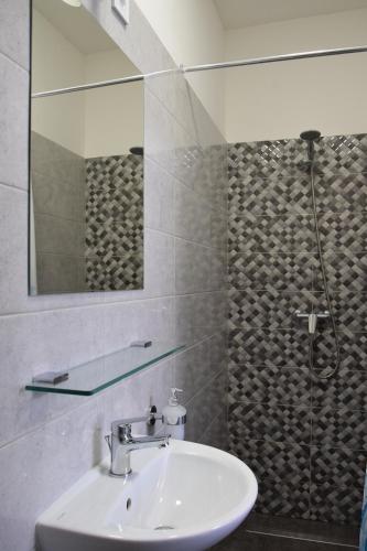 a bathroom with a sink and a mirror and a shower at Ház a tónál Noszvaj in Noszvaj