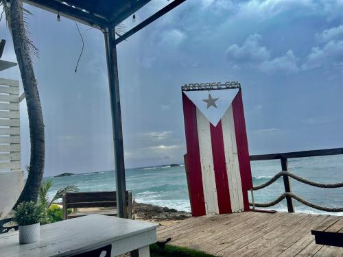 an american flag sitting on a deck next to the beach at Arecibo's country cottage in Arecibo