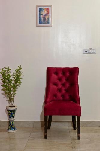 a red chair sitting next to a potted plant at City Central Hostel in Kolkata