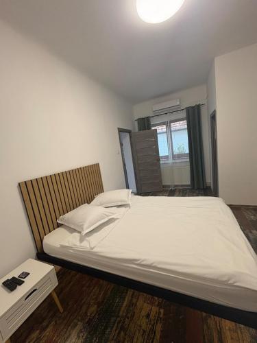 a bedroom with a large white bed and a window at Airport Green 2 in Cluj-Napoca