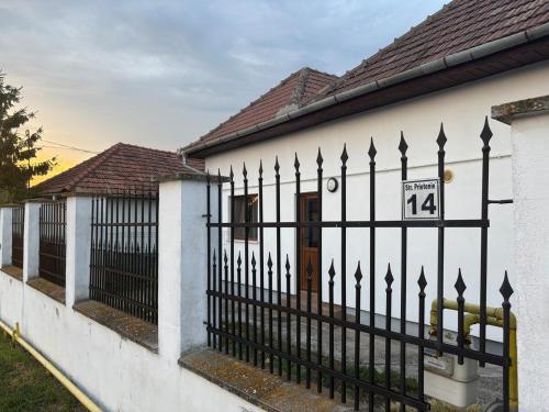 a white house with a fence with a sign on it at Airport Green 2 in Cluj-Napoca