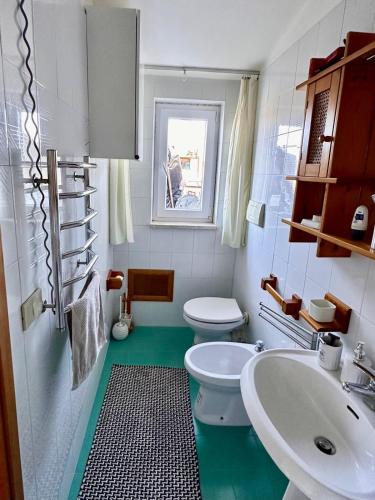 a bathroom with a white toilet and a sink at Fantastic sea & harbour view Nino Bixio in Castellammare del Golfo