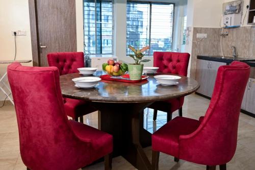 a dining room table with red chairs and fruit on it at City Central Hostel in Kolkata