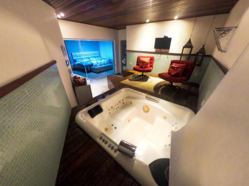 a large bath tub in a room with a bedroom at Pousada Liberal Liberte-se in Búzios- Somente Adultos in Búzios