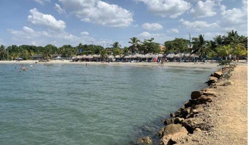 a beach with people and umbrellas on the shore at Condominio, Cabaña 202 in Puerto Viejo