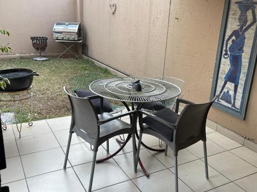 a patio table with four chairs and a bowl on it at The Northern Star in Sandton