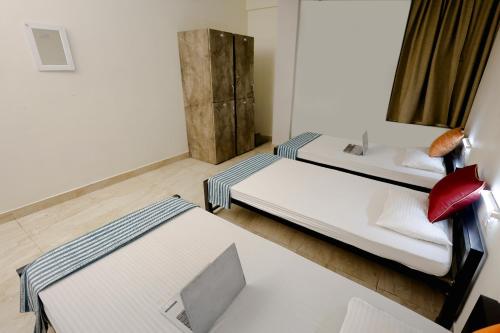 a room with two beds and a bench in it at City Central Hostel in Kolkata