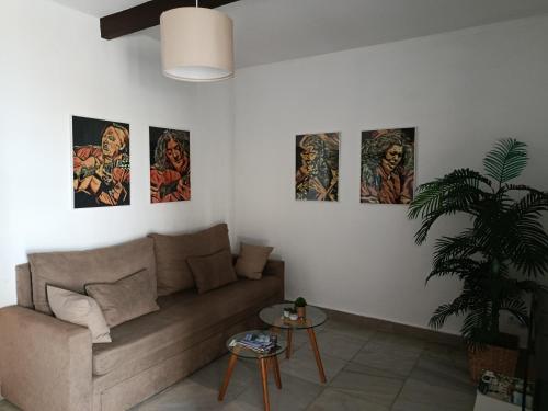 - un salon avec un canapé et quatre peintures murales dans l'établissement Apartamentos Casa Vicario, à Jerez de la Frontera