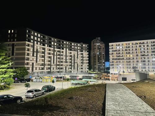 a large building with cars parked in a parking lot at Nova zgrada stan na dan Stupine G Tuzla Top Lokacija in Tuzla