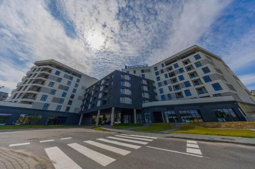 a large building with a crosswalk in front of it at Noble Inn Regency, City Centre, Free Parking by StayNest in Rzeszów