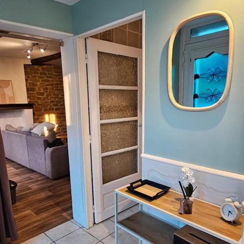 - un salon avec une table et un miroir dans l'établissement Maison de campagne lumineuse, à Renwez