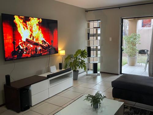 a living room with a fire on the wall at The Northern Star in Sandton