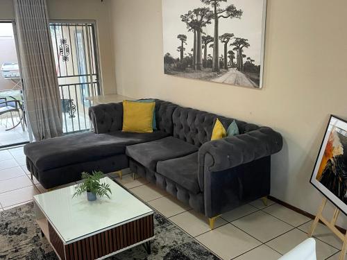 a living room with a black couch and a table at The Northern Star in Sandton