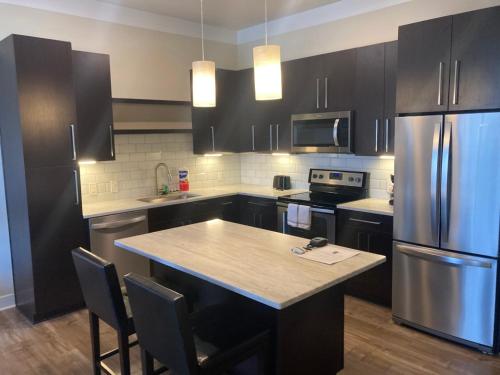 una cocina con armarios negros y una isla de cocina con nevera. en Beautiful in Beachwood, en Beachwood