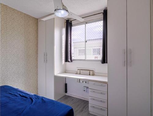 a bedroom with a blue bed and a window at Apto com ar-condicionado e vaga em Honorio Gurgel in Rio de Janeiro