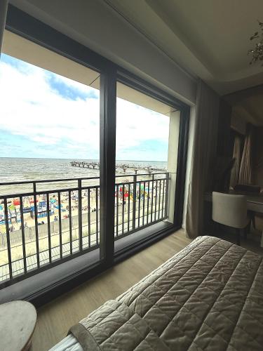 a bedroom with a view of the beach from a balcony at Luksusowy apartament Infinity Chill Baltic Spa in Międzyzdroje