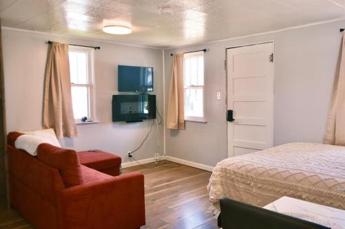 a bedroom with a bed and a chair and a television at Stylish Cabin by Mackinac in Saint Ignace
