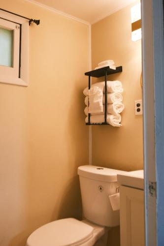 a bathroom with a toilet and towels on a shelf at Stylish Cabin by Mackinac in Saint Ignace