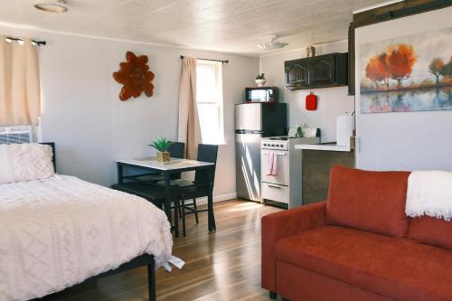 a bedroom with a bed and a table and a kitchen at Stylish Cabin by Mackinac in Saint Ignace