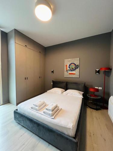 a bedroom with a large bed with towels on it at TIS, Green Coast in Palasë